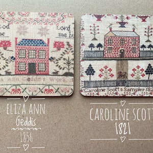 May include: Two framed cross-stitch samplers featuring a house and floral designs. The top sampler reads "Eliza Ann Geddis 1856" and the bottom sampler reads "Caroline Scott's Sampler 1821".
