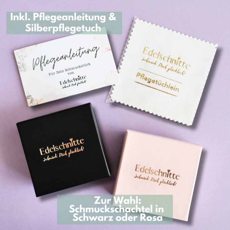 K&ouml;nnte beinhalten: Ein Set aus vier Schachteln mit dem Text "Edelschnitte" und dem Spruch "Schmack Dich gl&uuml;cklich!" in goldener Schrift. Die Schachteln sind schwarz, wei&szlig; und rosa. Der Text "Zur Wahl: Schmuckschachtel in Schwarz oder Rosa" befindet sich am unteren Rand des Bildes.