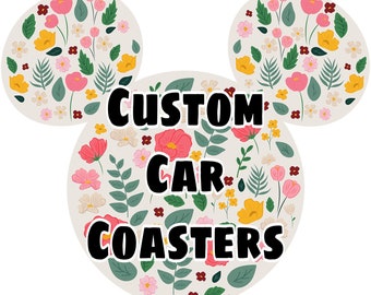 May include: Custom car coasters with a floral design. The coasters feature a white background with pink, yellow, and green flowers.