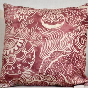 Könnte beinhalten: Ein rotes und weißes Kissen mit einem Batik-Muster. Das Kissen ist aus weichem Stoff und hat eine quadratische Form.