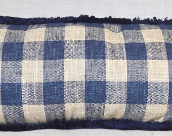 Puede incluir: Una almohada de cuadros azules y blancos con un borde de flecos azul marino.