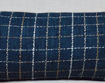 Puede incluir: Una almohada rectangular larga de color azul con un patrón de cuadrícula blanca y dorada.