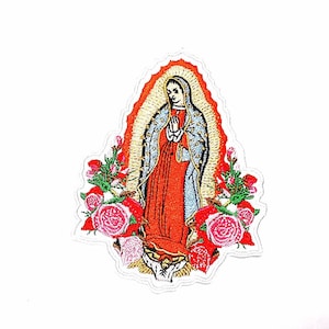 Può includere: Toppa ricamata raffigurante la Vergine Maria in abito rosso e scialle blu, circondata da rose rosse e rosa. L'immagine ha un'aureola dorata ed è ambientata su uno sfondo bianco. La toppa è probabilmente per abbigliamento o accessori.