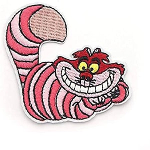 Op de afbeelding: Geborduurde patch met de Cheshire Cat uit Alice in Wonderland. De patch heeft een rood-roze gestreept lichaam en staart, een groot lachend gezicht, gele ogen en een bruin vlekje op de staart.