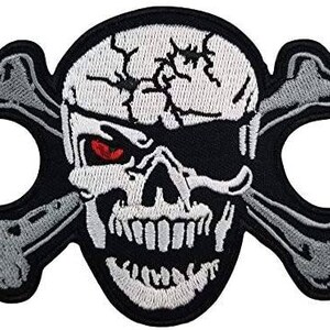 Puede incluir: Parche bordado con una calavera con un ojo rojo, un parche en el ojo y huesos cruzados. La calavera es blanca con detalles negros y un borde negro. Los huesos cruzados son grises con contornos blancos.