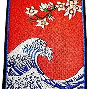 Può includere: Toppa ricamata con un motivo a onda giapponese e un ramo di fiori di ciliegio su sfondo rosso. L'onda è bianca e blu, con un bordo nero e blu. Ispirato all'arte giapponese.