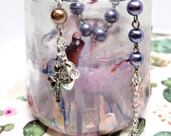 Adjustable rosary bracelet (6in to 7in) of pearly purple beads.