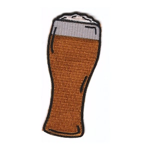 May include: Embroidered patch depicting a pint of beer. The glass is filled with a brown liquid, with a grey section at the top representing the head of the beer. The patch has a black outline and is designed for fabric.