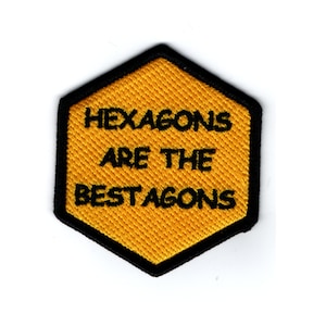 May include: A yellow hexagonal patch with black stitching and the text "Hexagons are the bestagons" in black.