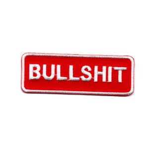 Può includere: Toppa rettangolare rossa con testo ricamato bianco che recita "BULLSHIT".