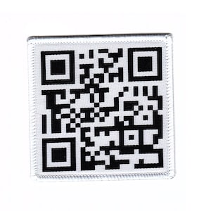 Könnte beinhalten: Ein weißer Stoff-Patch mit einem schwarz-weißen QR-Code darauf gedruckt. Der Patch hat einen weißen Rand mit einem genähten Rand.