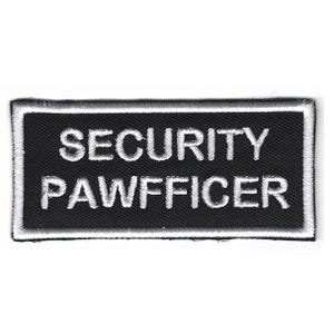 Puede incluir: Parche bordado en blanco y negro con el texto "SECURITY PAWFFICER" en un contorno blanco.