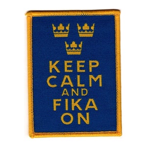Może przedstawiać: Naszywka haftowana w kolorze niebieskim i złotym z trzema złotymi koronami i tekstem "Keep Calm and Fika On".