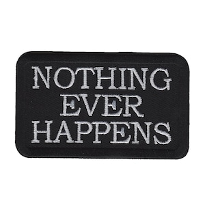 Pode incluir: Patch retangular preto com cantos arredondados. O patch apresenta o texto bordado "NOTHING EVER HAPPENS" em branco, centrado no fundo preto. O texto está em negrito, fonte sem serifa.