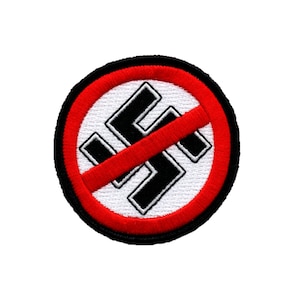 Może przedstawiać: Czerwone koło z czarnym obramowaniem i przekątną czerwoną linią przecinającą czarny symbol swastyki. Swastyka znajduje się na białym tle.