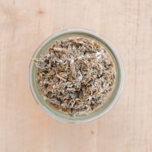 May include: A glass jar filled with dried herbs, likely for use in teas or other herbal remedies.