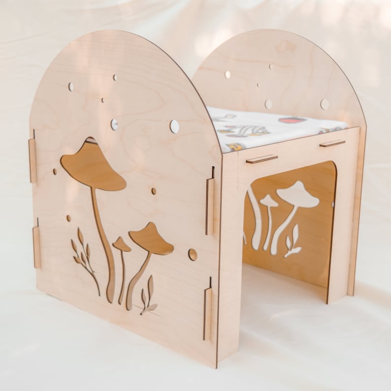 Puede incluir: Una casita de madera para mascotas peque&ntilde;as, con un dise&ntilde;o de corte de setas y hojas. La casita tiene un techo extra&iacute;ble y una peque&ntilde;a abertura en el lateral.