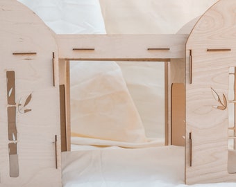 May include: A wooden playhouse with a simple design, featuring a cutout of a bamboo plant on each side. The playhouse has a flat roof and a small opening in the front.