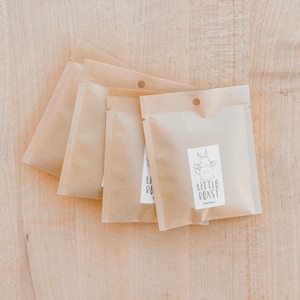 Four Packages of dried herbs on top of a wooden cutting board