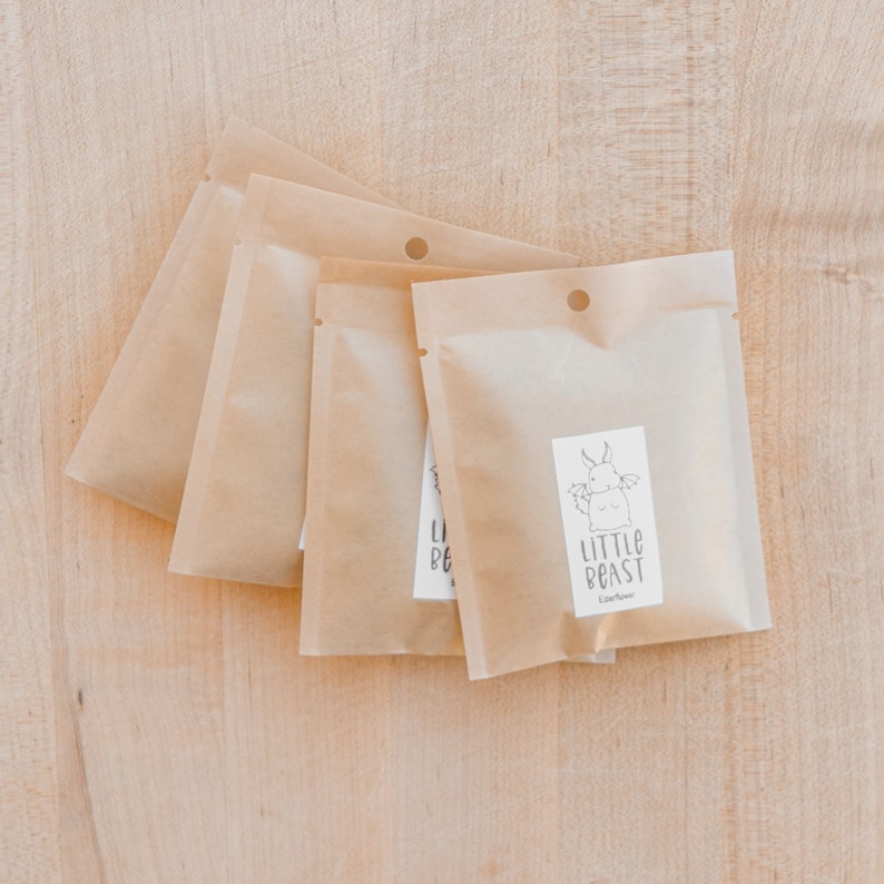 Four Packages of dried herbs on top of a wooden cutting board
