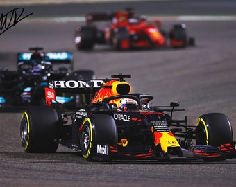 Puede incluir: Un coche de carreras de Fórmula 1 negro y rojo con la palabra "Oracle" en el lateral. El coche está en una pista de carreras.