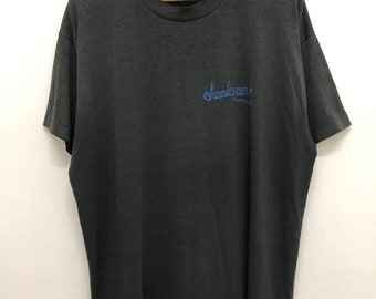 Vintage 90s JACKSON GUITARS camiseta promocional belleza desgastada material suave y delgado punto único hecho en EE.UU. camiseta estilo héroe de guitarra rockstar
