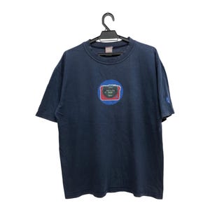 May include: A dark blue t-shirt featuring a graphic of a red and blue cassette player with the text "Sonic Boom" on it.