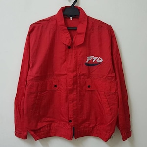 May include: A red windbreaker jacket with a black zipper and snap closure. The jacket has two pockets on the front and a white and blue logo that says "FTO" on the left chest.