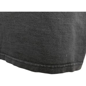 Puede incluir: Primer plano de una camiseta gris oscuro. La tela tiene un aspecto ligeramente texturizado, con costuras visibles a lo largo del dobladillo. La imagen se centra en la parte inferior de la camiseta, destacando la textura y la construcci&oacute;n.