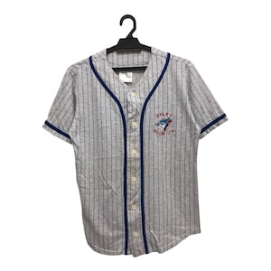May include: Gray and white striped baseball jersey with blue trim and buttons. The jersey features the text "Wyley Blue Jays" and a logo of a blue jay bird. The shirt is hanging on a black hanger.