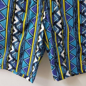 May include: Blue and yellow patterned swim trunks with the Kappa logo on the right leg.