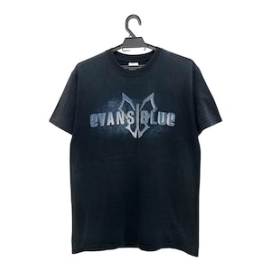May include: Black t-shirt with the band name "EVANS BLUE" in a stylized, silver font across the chest. The design includes a central emblem. The shirt is hanging on a black hanger.