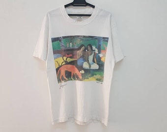 May include: White t-shirt with a colorful painting of two women and a dog in a forest setting. The painting is signed "Gauguin" and dated "1891".
