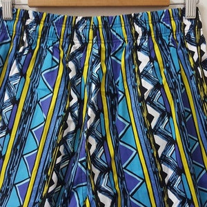 May include: Blue, yellow, and purple patterned shorts with a geometric design.