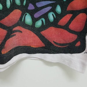 Puede incluir: Primer plano de una tela negra y blanca con un dise&ntilde;o abstracto colorido. La tela tiene un borde blanco y la firma "Nicholson" es visible en la esquina inferior derecha.