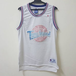 May include: White basketball jersey with blue and red trim. The jersey has a large graphic of the Tune Squad logo with the text "Tune Squad" in blue and white.