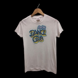 Op de afbeelding: Wit T-shirt met korte mouwen met een blauwe en gele afbeelding met de tekst "Barbie Dance Club".