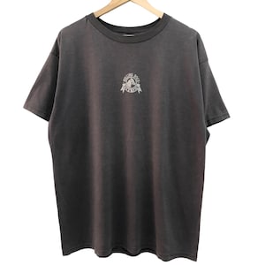 Puede incluir: Una camiseta gris oscuro con un gráfico blanco de una calavera y huesos cruzados con el texto "Rolling Bones" debajo.