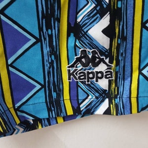May include: Blue, yellow, and white patterned swim trunks with a black Kappa logo.