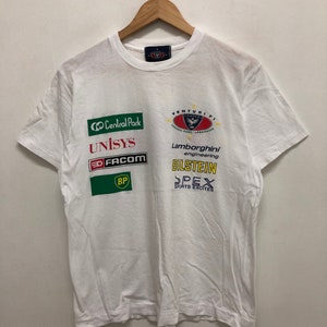 Op de afbeelding: Wit T-shirt met verschillende logo's bedrukt op de voorkant, waaronder Central Park, Unisys, Facom, BP, Venturi F1, Lamborghini Engineering, Bilstein en Spex Sports Excite.