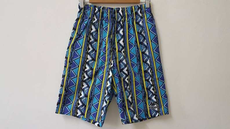 May include: Blue, yellow, and white patterned shorts with a black logo that says "Kappa" on the right leg.