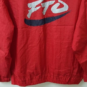 May include: Red windbreaker jacket with a white and blue logo that says "FTO" in a stylized font.