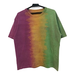 May include: A tie-dye t-shirt with a gradient of purple, orange and green. The shirt has the text "HYPER COLOUR" printed on the front.