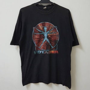 May include: Black t-shirt with a graphic of a blue alien figure in a circle with a red and orange background. The text "VOYAGER" is printed below the graphic.