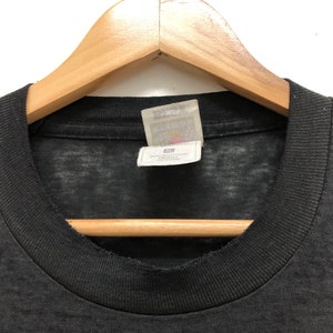 May include: Black t-shirt with a faded look and a white tag that says "Liquid Blue" with a small graphic of a star.