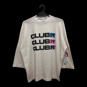 May include: White long-sleeve shirt with the text "CLUB MTV" in black, blue, pink, and purple. The shirt has a crew neck and a graphic on the sleeve. The shirt is hanging on a black hanger.