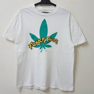 May include: White t-shirt with a green marijuana leaf and the text "Flower Power" in yellow letters.