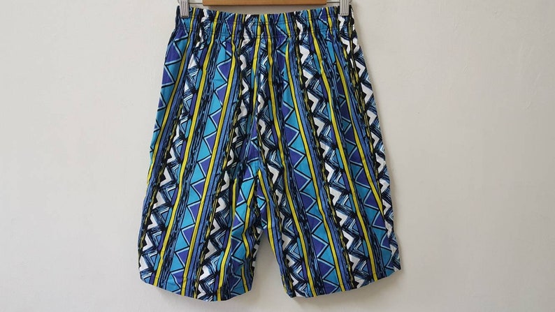 May include: Blue, yellow, and white patterned shorts with a geometric design.