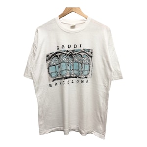 May include: White t-shirt with a graphic print of a building with the text "GAUDI BARCELONA".