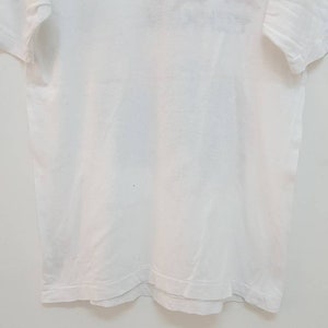 May include: A plain white t-shirt with short sleeves.